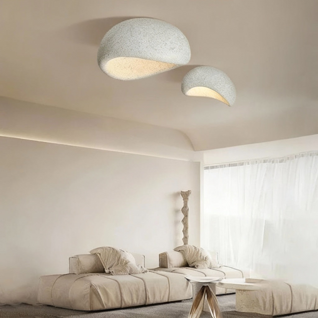 Modern living room with two concrete pendant lights, a sofa, and a table.